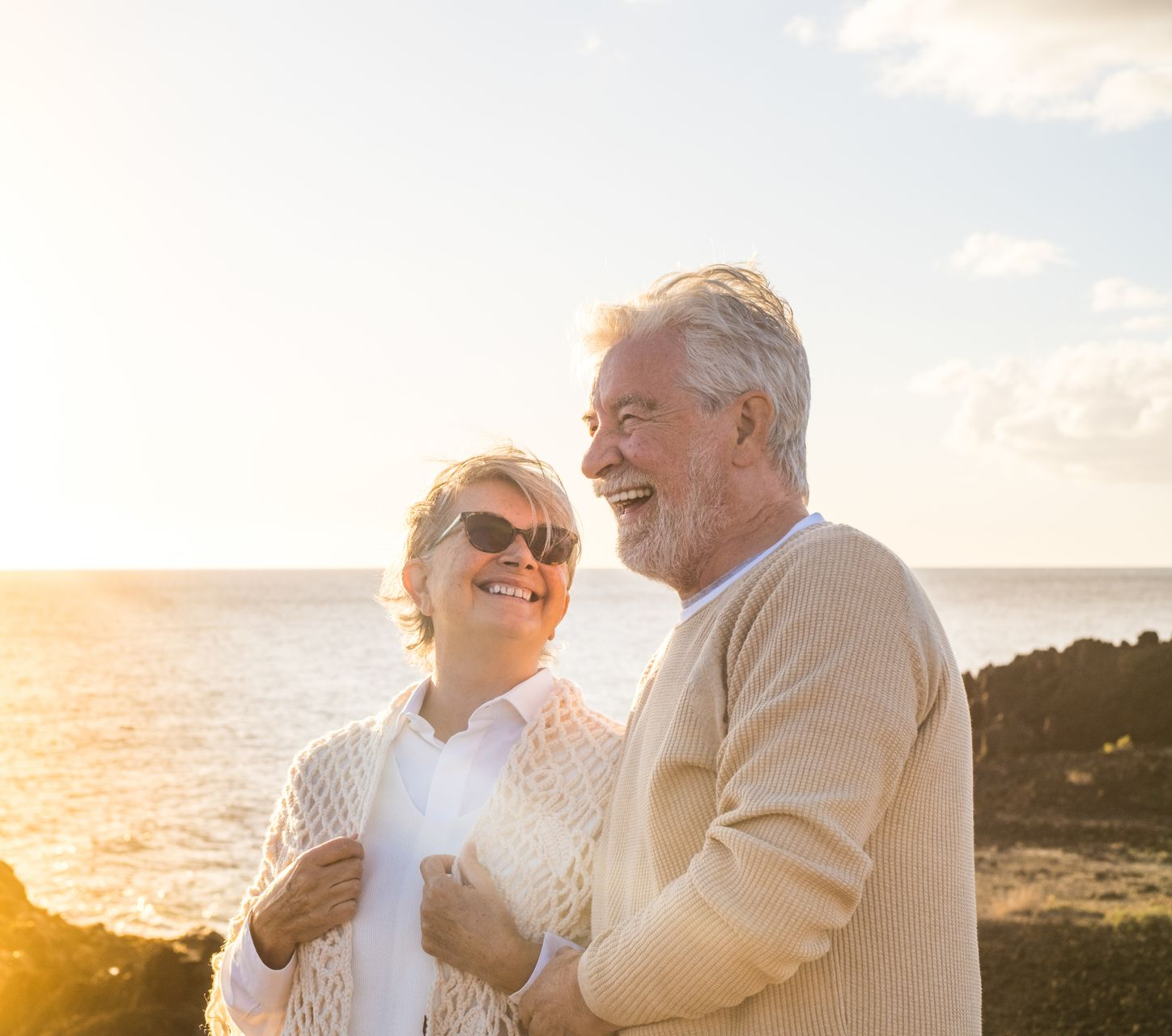 A man with a backpack is standing next to a lake in the woods.