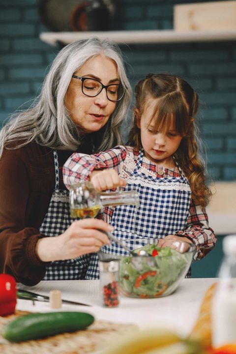 Man and woman in an office, reviewing papers. Man smiles, woman reaches to hand over a document.
