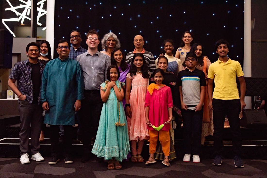 Group of people posing together indoors, in front of a starry backdrop.