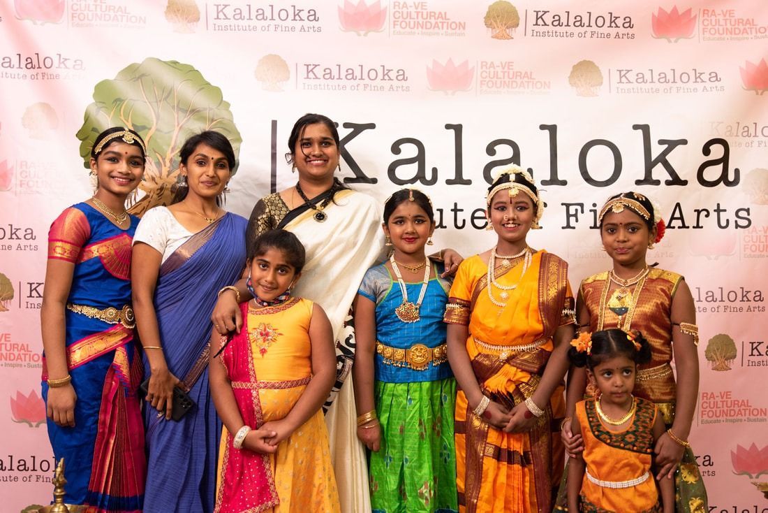 Group of people posing for a photo. They are in traditional Indian clothing, standing in front of a banner that reads Kalaloka Institute of Fine Arts.