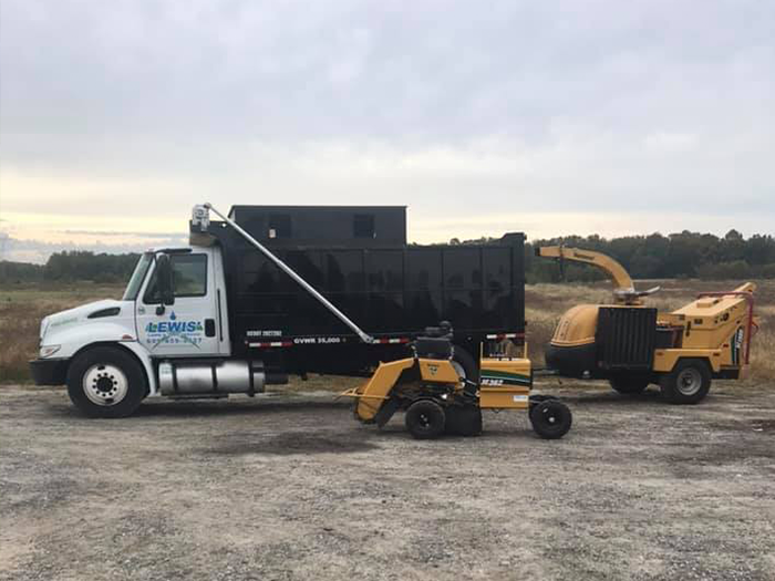 A dump truck with a tractor attached to it is parked in a field.