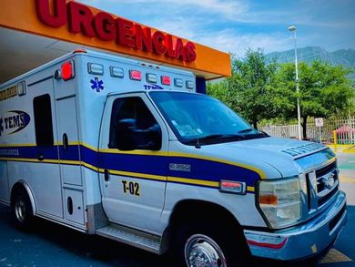 Ambulancia estacionada frente a letrero de