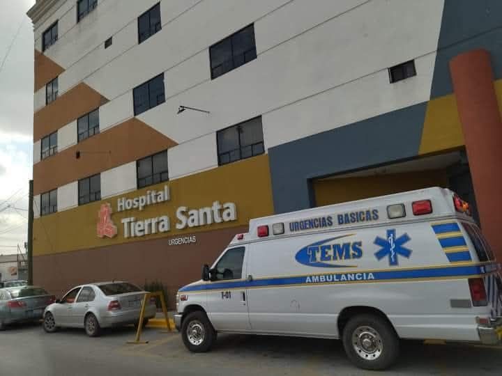 Exterior del Hospital Tierra Santa con ambulancia y coches.