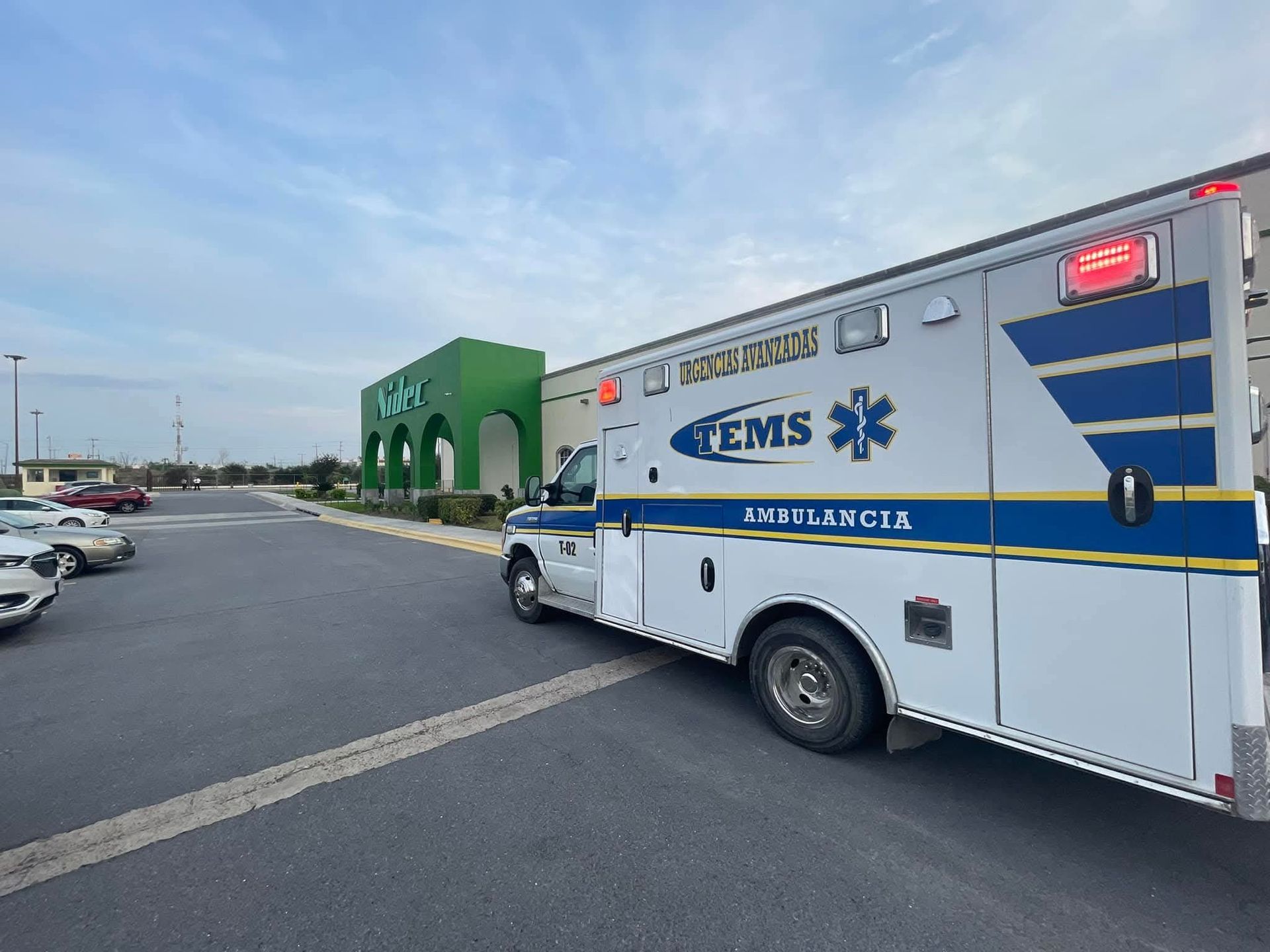 Ambulancia estacionada cerca de un edificio verde, probablemente respondiendo a una emergencia médica.