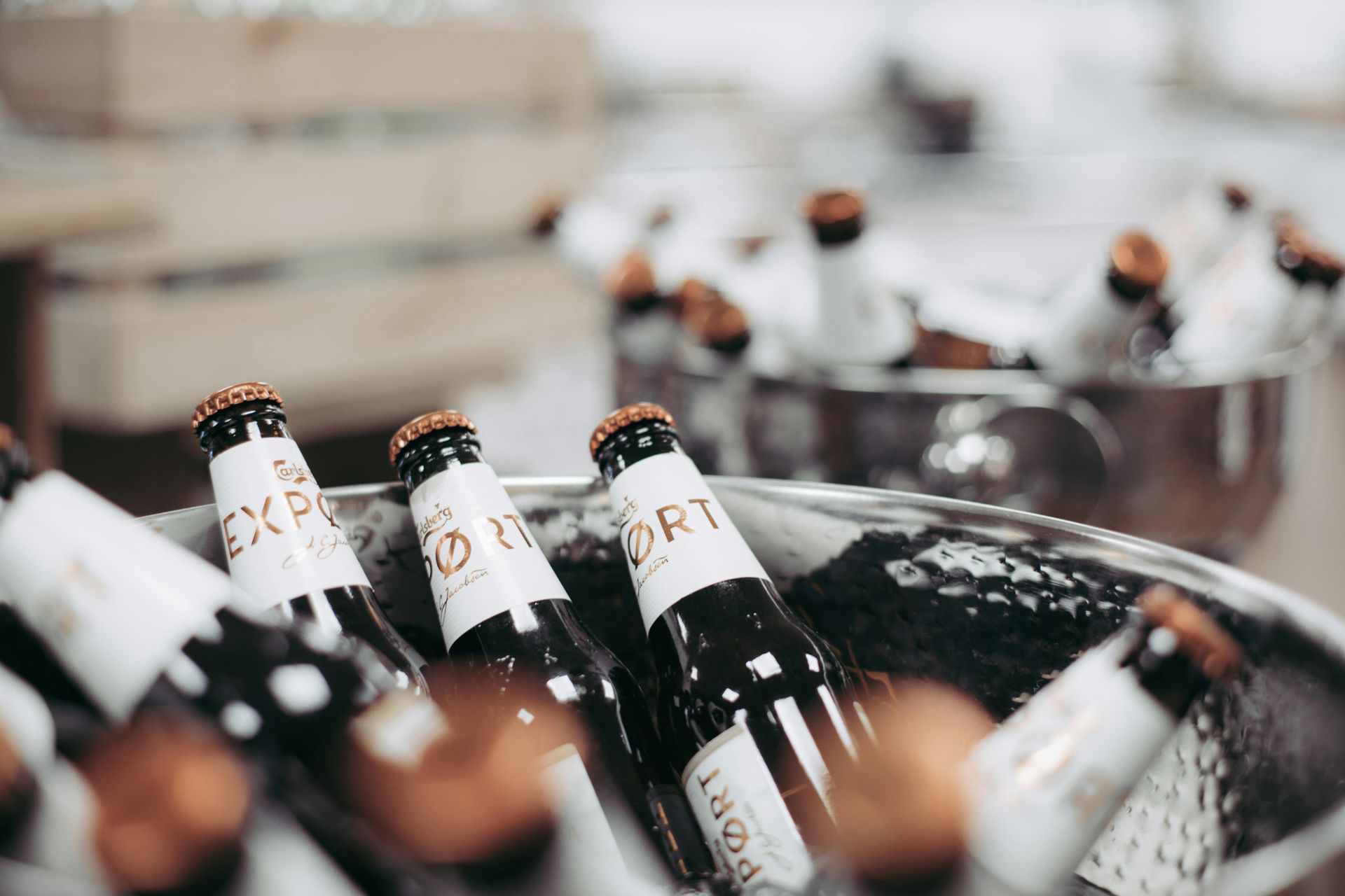 A bucket filled with bottles of beer is sitting on a table.