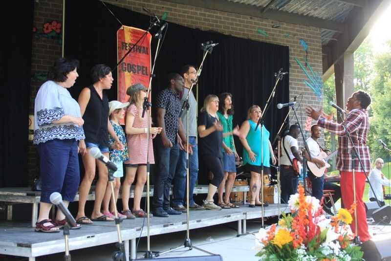 Un groupe de personnes debout sur une scène chantant dans des microphones