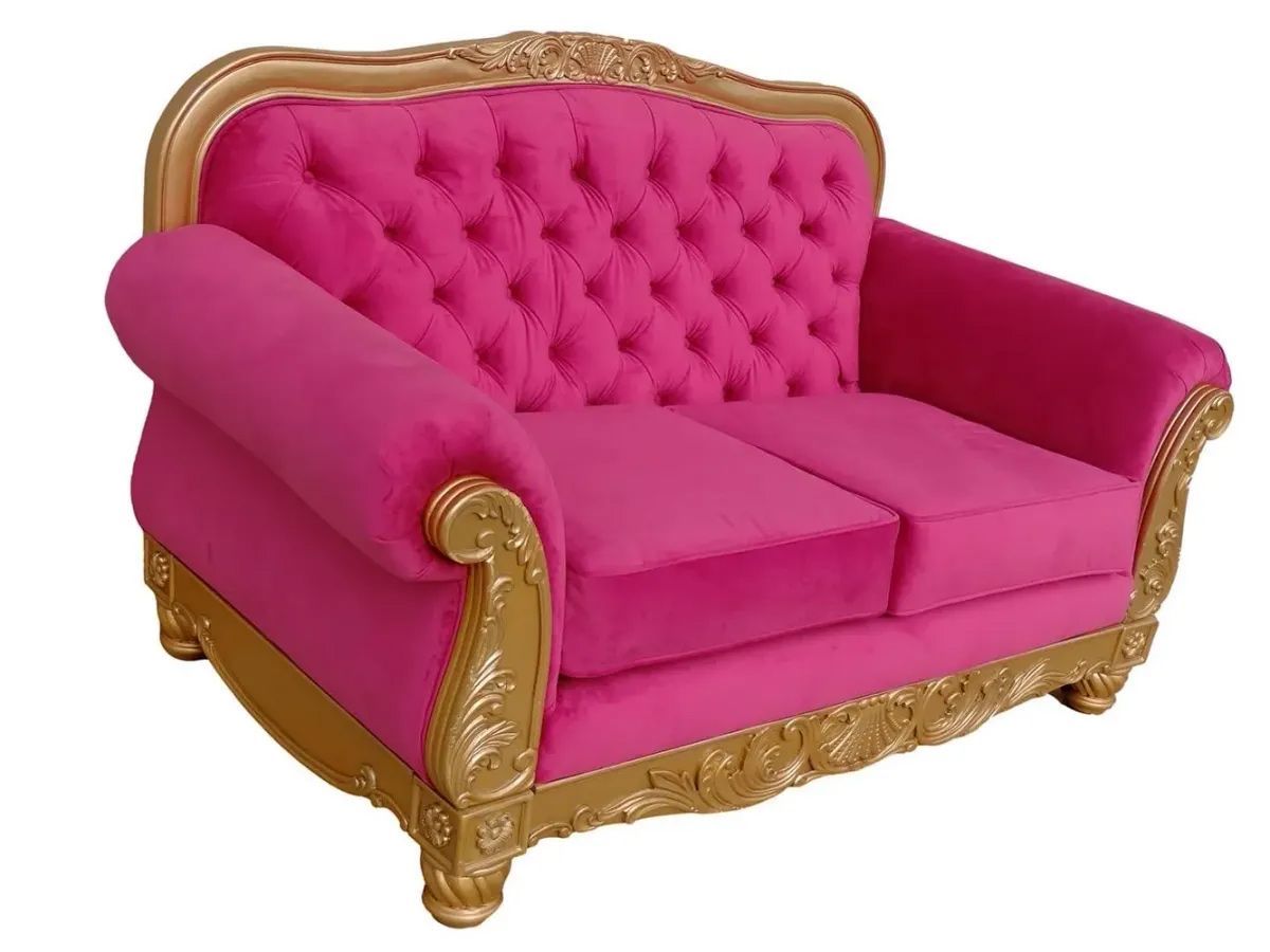A pink couch with gold trim on a white background