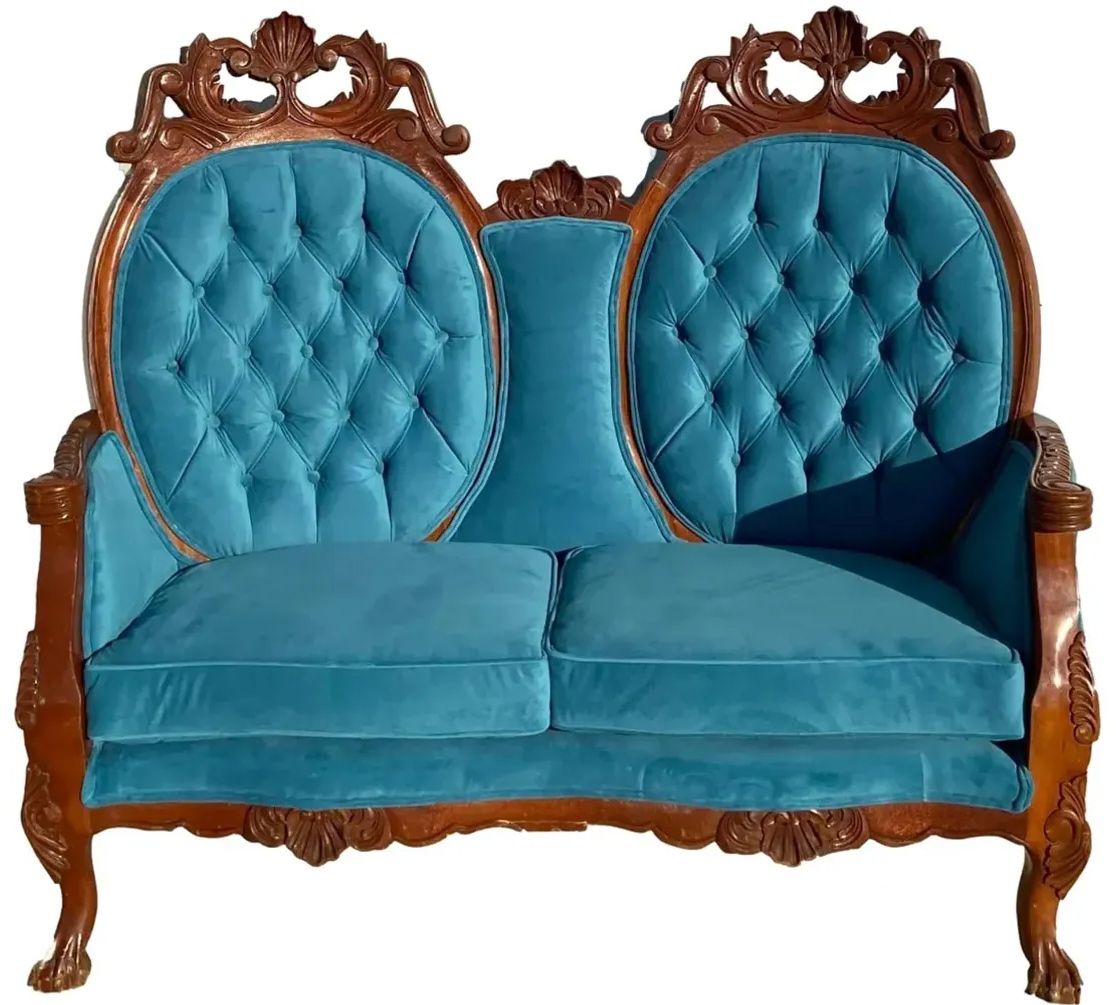 A blue couch with a wooden frame on a white background