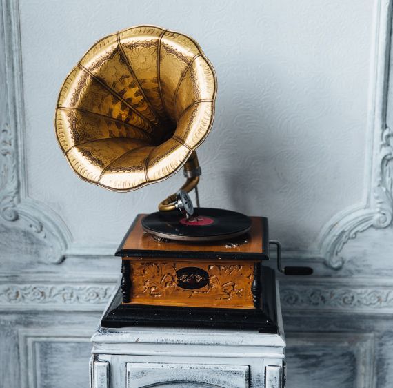 An old phonograph is sitting on top of a table.