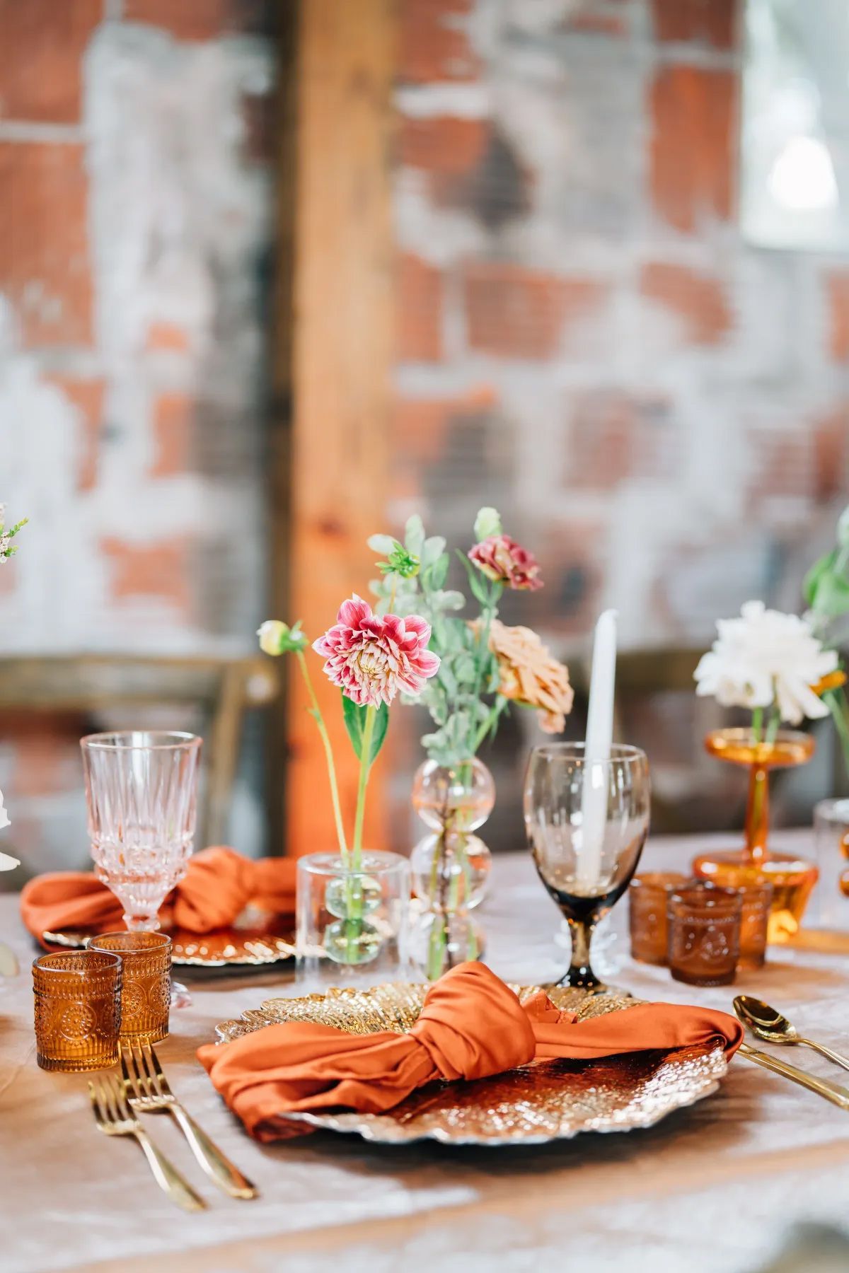 A table set for a wedding reception with a brick wall in the background.