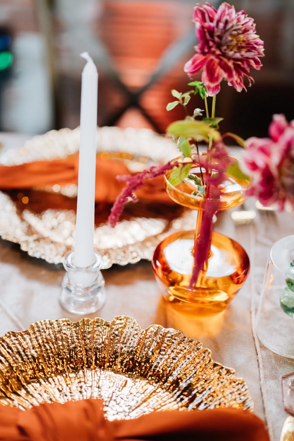 A table setting with a vase of flowers and a candle.