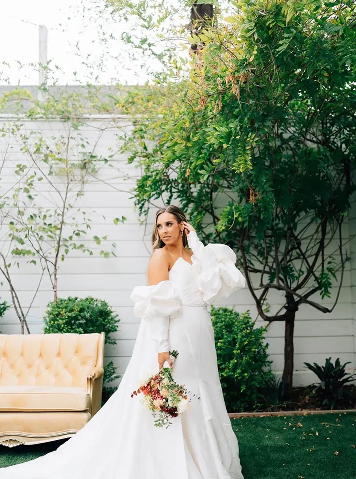 The bride is wearing a white dress and holding a bouquet of flowers.