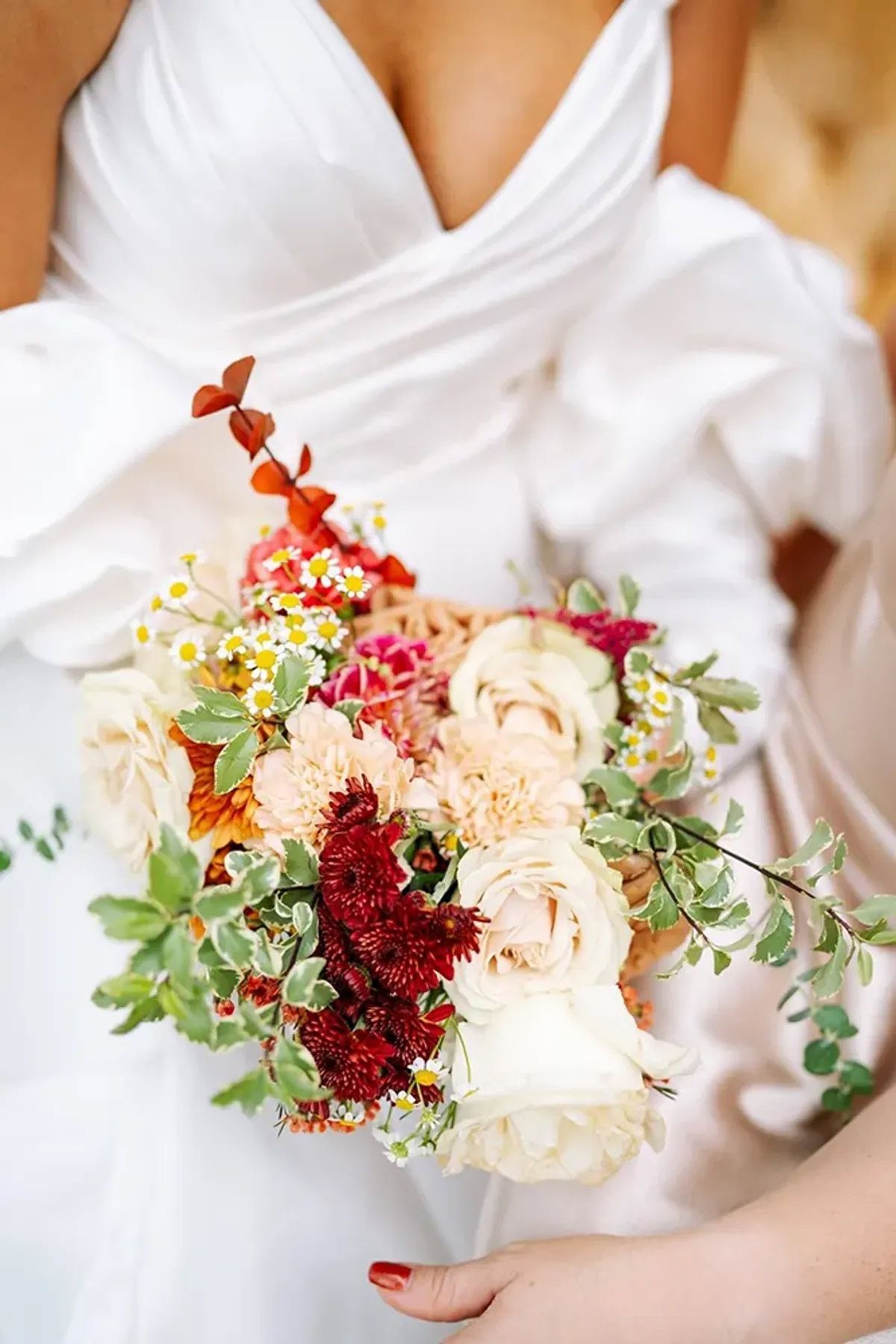 A bride in a white dress is holding a bouquet of flowers.