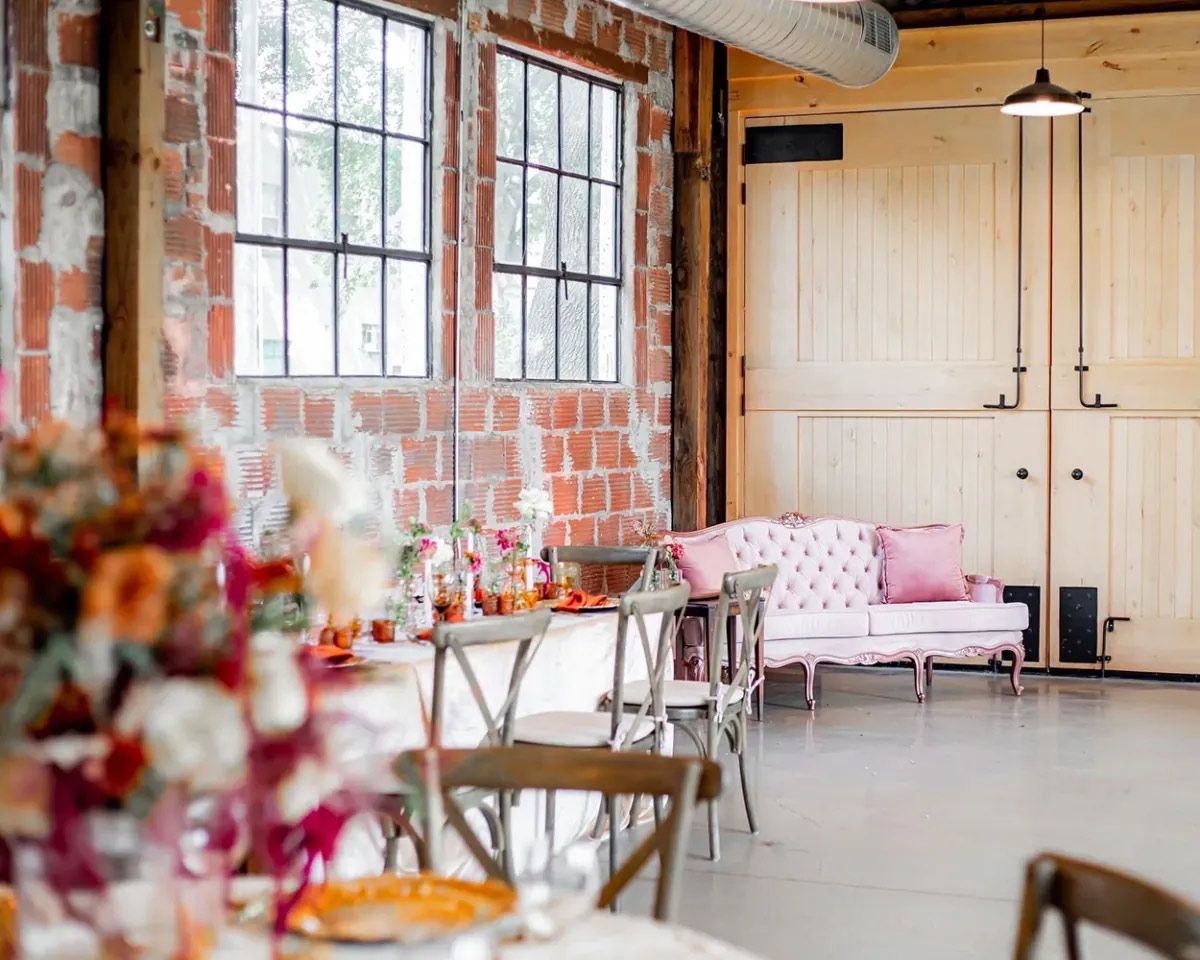 There is a pink couch in the middle of the room.