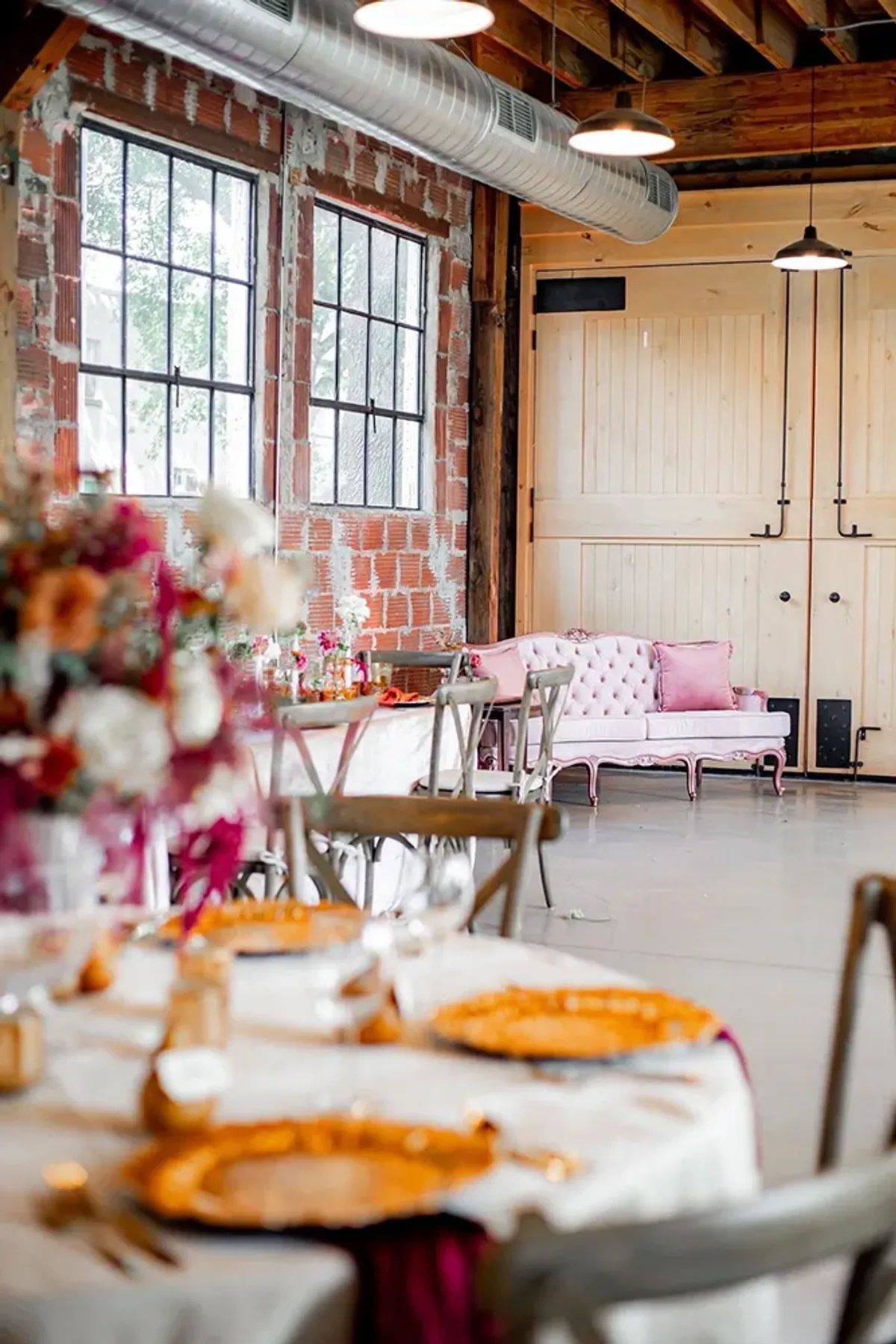 A room with tables and chairs set up for a wedding reception.
