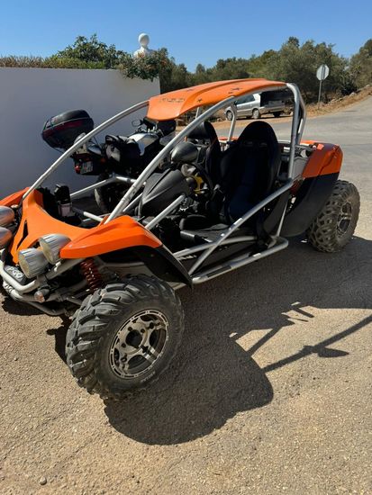 An orange buggy is parked on the side of the road