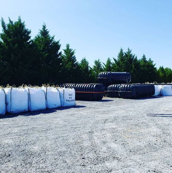 A bunch of bags are stacked on top of each other in a parking lot