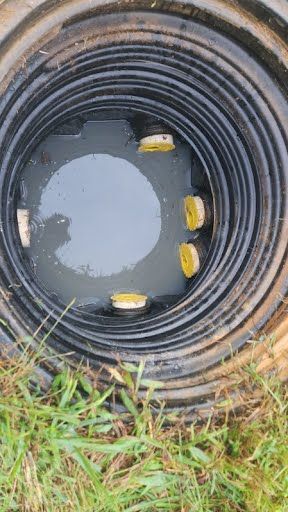 A close up of a manhole cover filled with water.