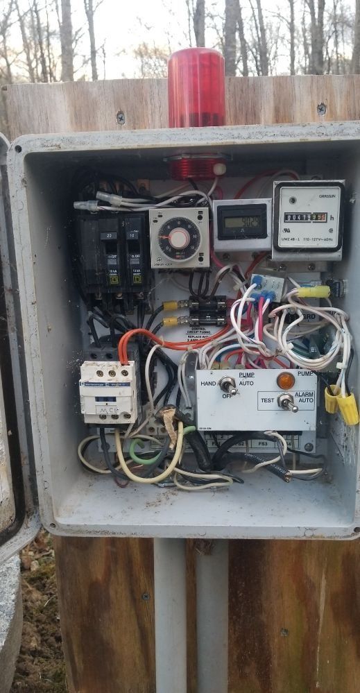 A box filled with lots of wires and a red light.