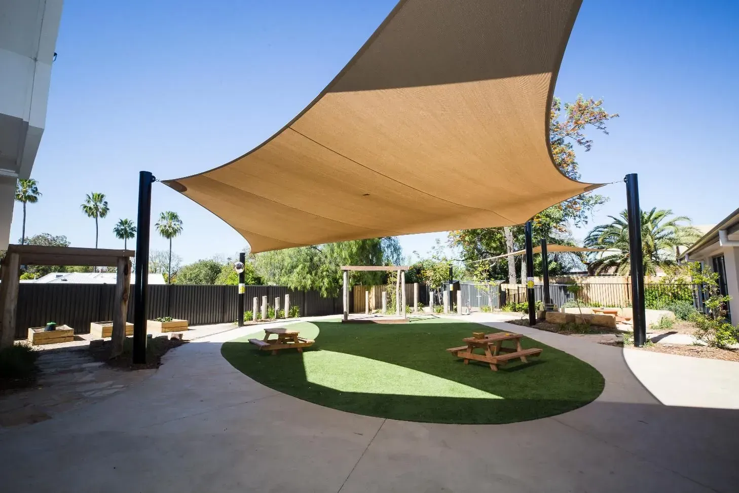 A Large Shade Sail Is Covering A Grassy Area In A Yard — D&C Projects in Lake Macquarie, NSW