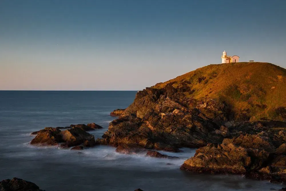 A Lighthouse On Top Of A Rocky Hill Overlooking The Ocean — D&C Projects in Port Macquarie, NSW