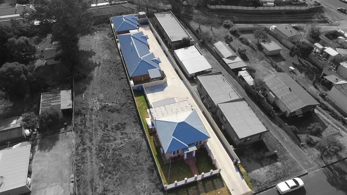 An Aerial View Of A Row Of Houses With Blue Roofs — D&C Projects in Maitland, NSW