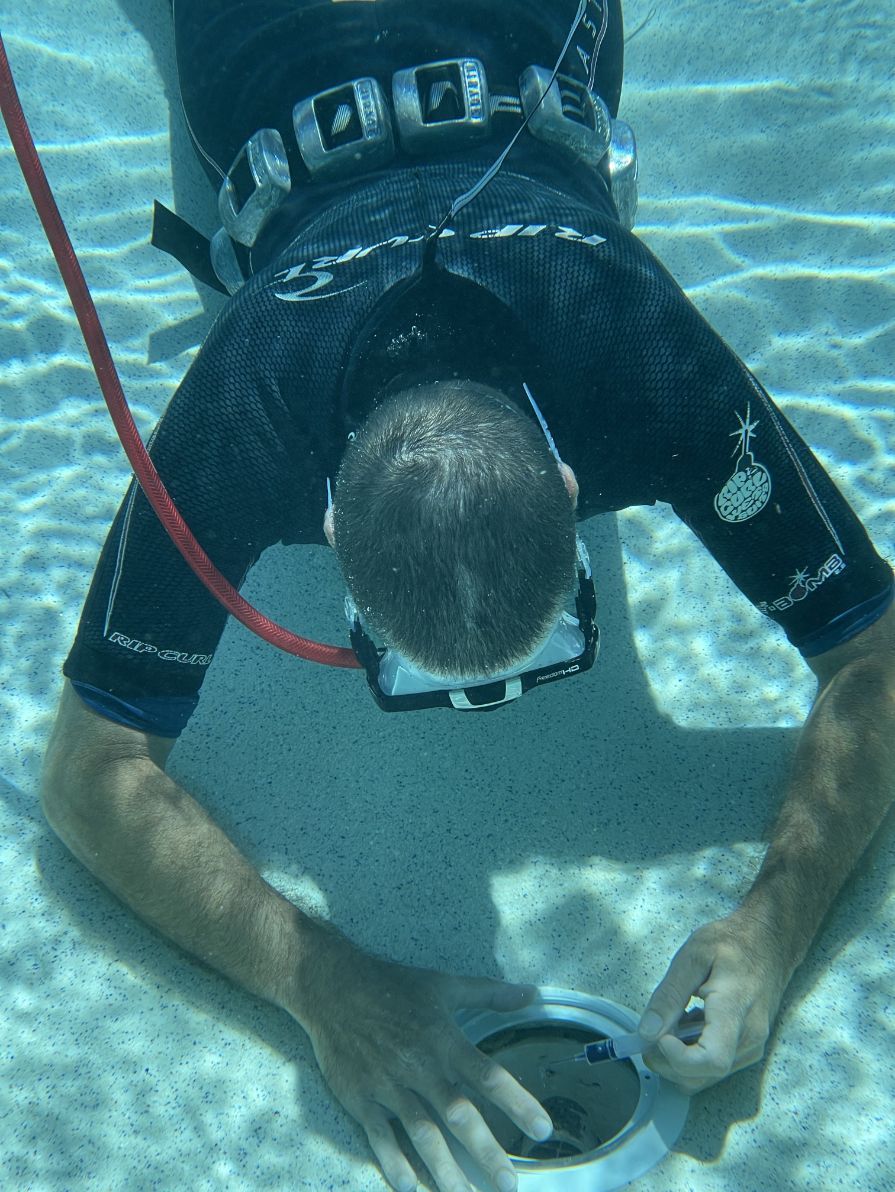 Man With Goggles Fixing Leak Under The Water — Leak Detection & Swimming Pool Repairs in Ballina, NSW