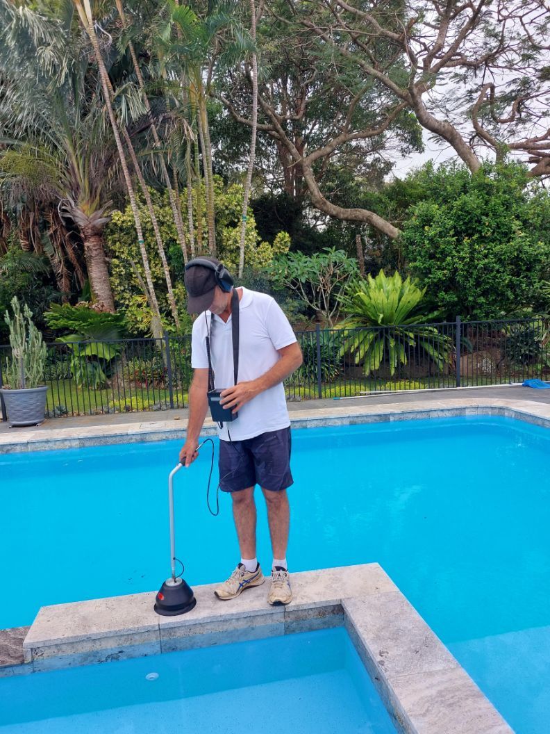 Man Detecting Leak Beside The Pool Using An Equipment — Leak Detection & Swimming Pool Repairs in Ballina, NSW