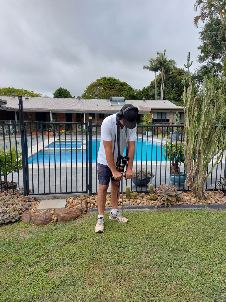 Man Using An Equipment On A Green Grass — Leak Detection & Swimming Pool Repairs in Ballina, NSW
