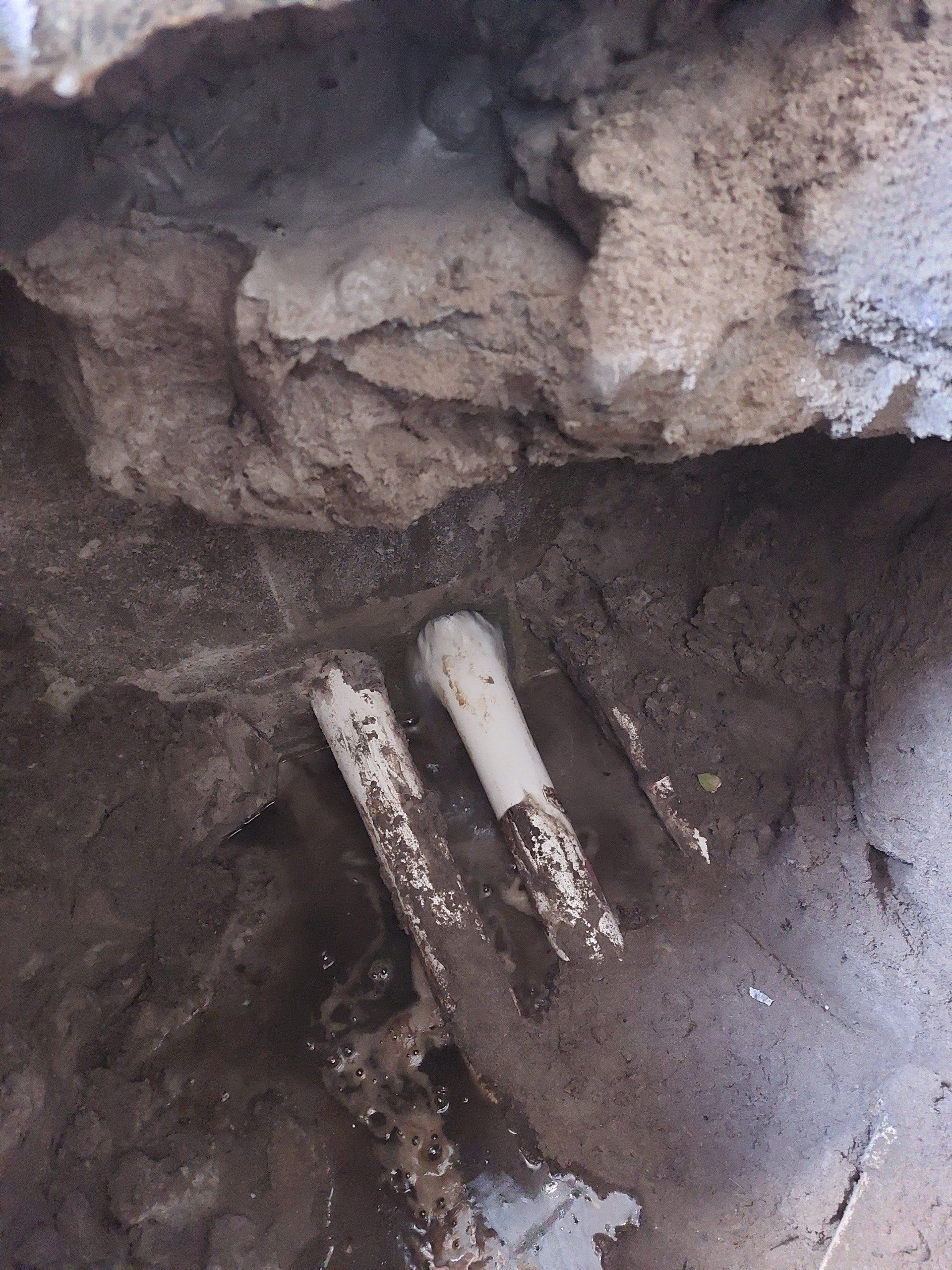 A close up of a pipe in a hole in the ground
