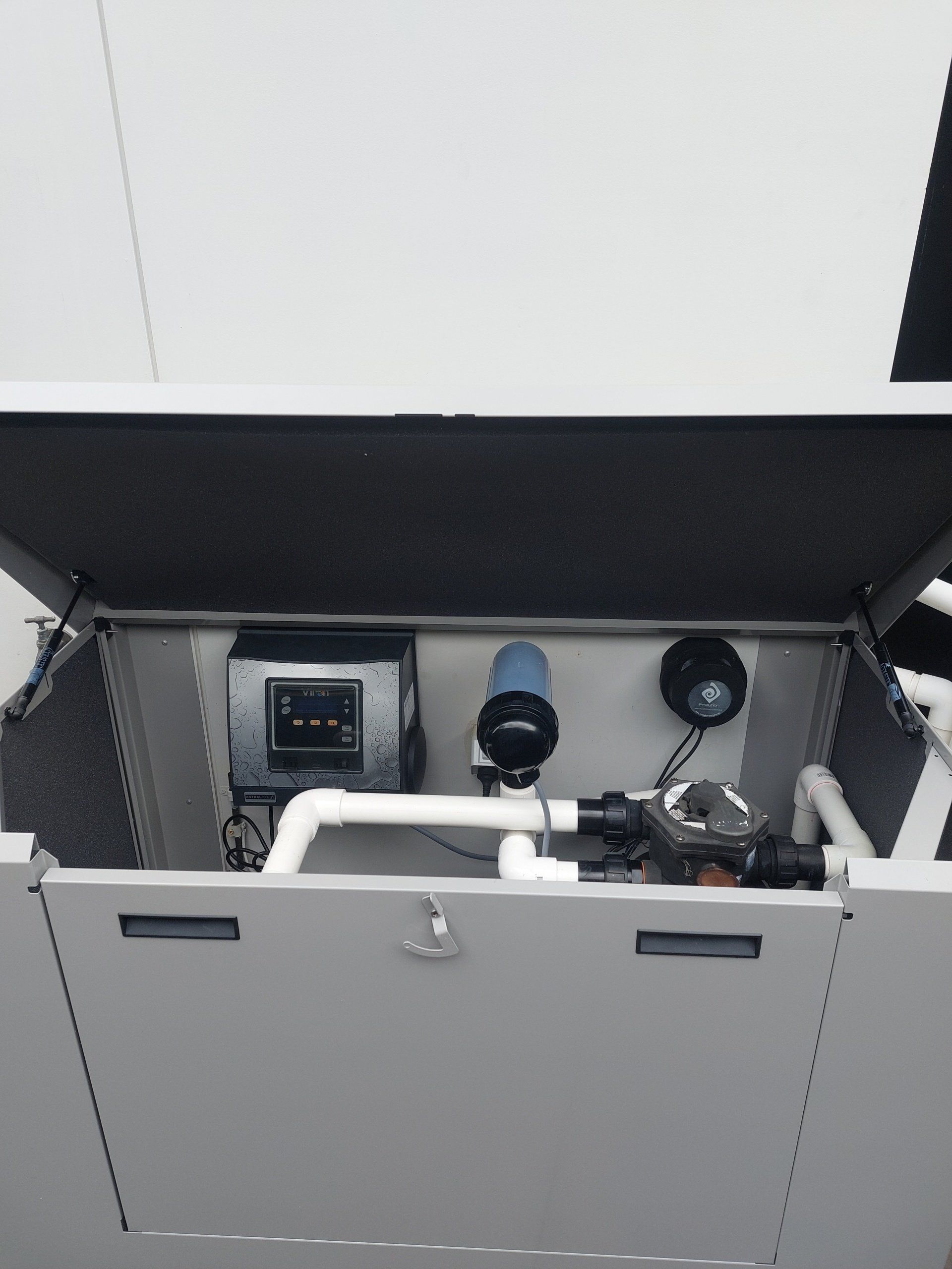 A gray box with the lid open and a few pipes inside