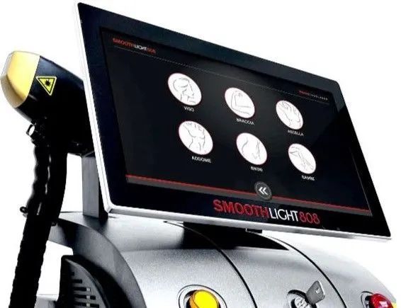 Un dispositivo professionale per la depilazione laser di colore argento con interfaccia touchscreen che visualizza icone relative alle diverse zone del corpo.