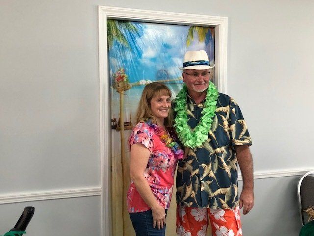 A man and a woman are posing for a picture in front of a door.