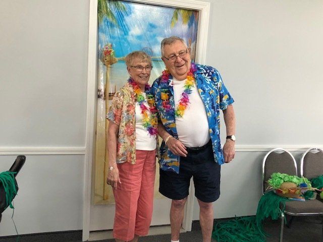 A man and a woman are standing next to each other in front of a door.
