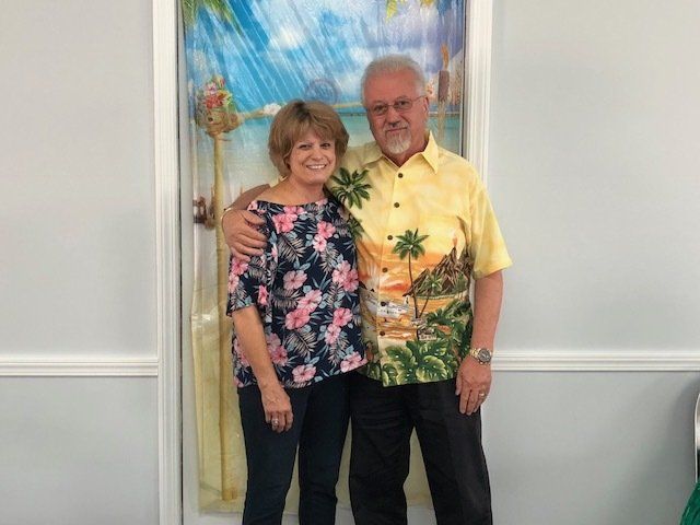 A man and a woman are posing for a picture in front of a door.