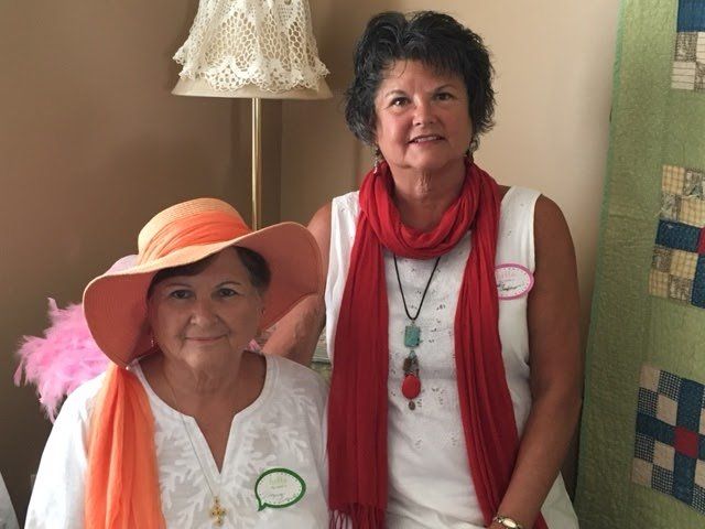 Two women wearing hats and scarves are posing for a picture