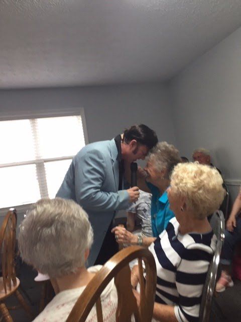 A man in a blue suit is talking to a group of people