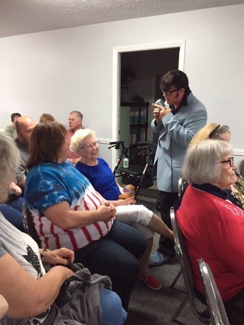 A man is taking a picture of a group of people sitting in chairs