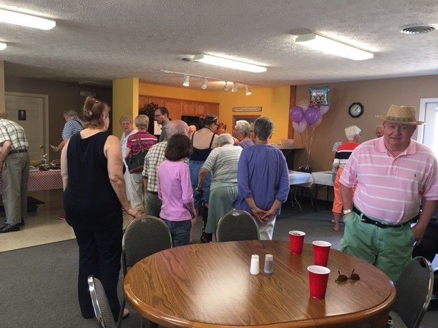 A group of people standing around a table with red cups on it
