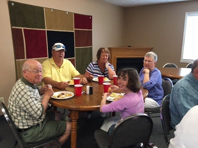 A group of people are sitting around a table eating food