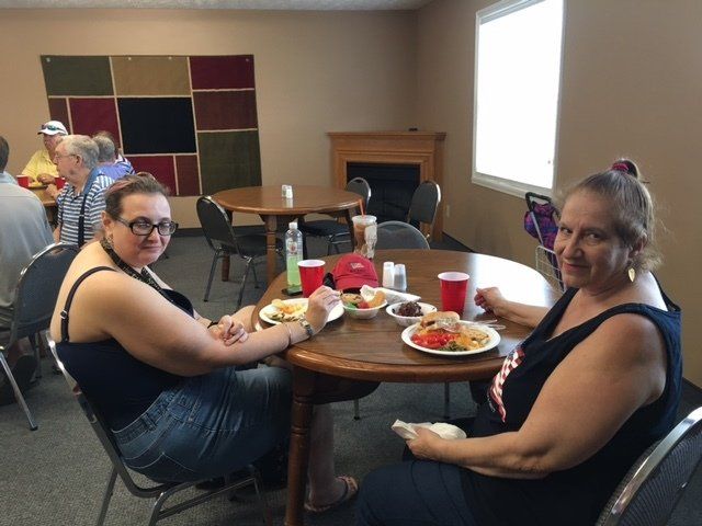Two women are sitting at a table with plates of food