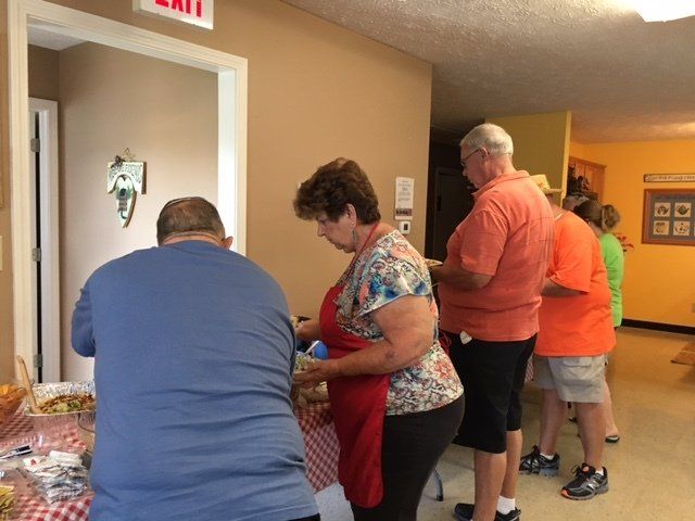 A group of people are standing around a table in front of an exit sign