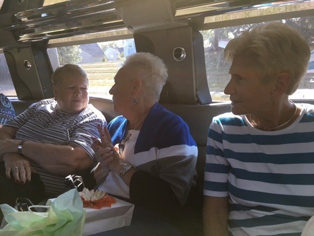 A group of people are sitting on a bus talking to each other.