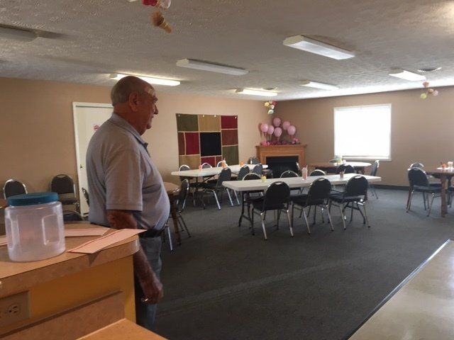 A man standing in a room with tables and chairs