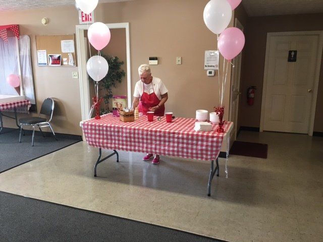 A woman is standing at a table with balloons on it