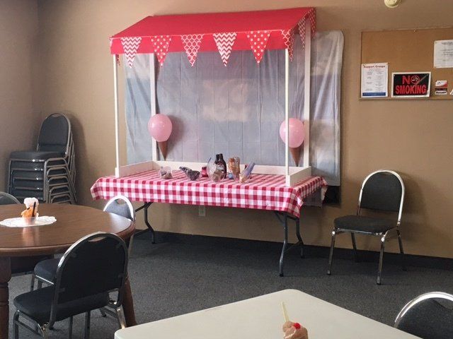 A room with tables and chairs and a popcorn cart