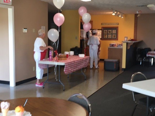 People standing around a table with pink and white balloons