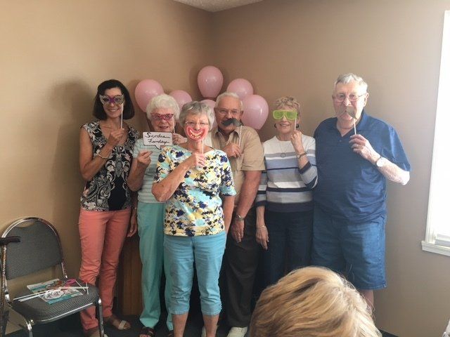 A group of people are posing for a picture with balloons in the background.