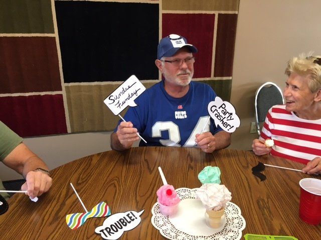 A man sitting at a table holding a sign that says trouble