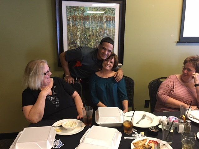 A group of people are sitting at a table with plates of food.